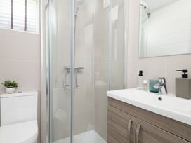 A bathroom with a shower and sink at Sennen 3 Spa (Pet) Bude