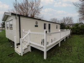 A mobile home with a deck and railing at Willerby Ellerrton (delyn)