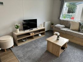 A living room with a television and coffee table at Willerby Ellerrton (delyn) Prestatyn
