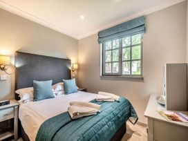 A bedroom with a bed, bedside table and window at Arran Lodge Spa Dailly