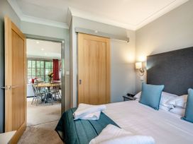 A bedroom with a bed and door leading to a dining area at Arran Lodge Spa Dailly