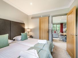 A bedroom with twin beds and an open doorway at Arran Lodge Spa Dailly