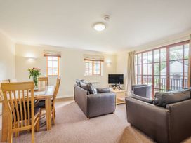 A living room with a sofa, dining table, and television at Turnberry in Dailly