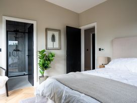 A bedroom with a bed, plant, and access to a shower at Cabin 2.0 in Dumfries