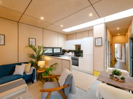 A living room with a sofa and a kitchen at Orka 2.0 Kinder (Pet) Dumfries