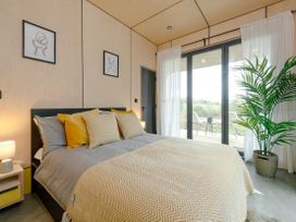 A bedroom with a bed and curtains at Orka 2.0 Kinder (Pet) Dumfries