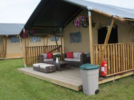 A patio with outdoor seating and a coffee table at Standard Safari Tent in Fair Oak