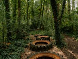 A forest path with tires on the ground at Standard Safari Tent in Fair Oak