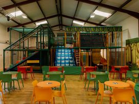 A play area with a large play structure and tables at Standard Safari Tent in Fair Oak