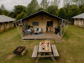 An outdoor area with a tent and seating at Deluxe Safari Tent in Fair Oak