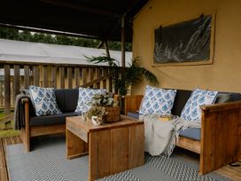 An outdoor seating area with a couch and coffee table at Deluxe Safari Tent in Fair Oak