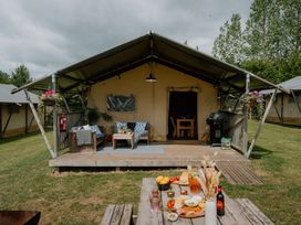 An outdoor area with a tent and seating at Deluxe Safari Tent in Fair Oak