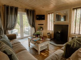 A living room with a sofa, coffee table and television at Spitfire Lodge in Fair Oak