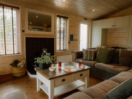 A living room with a table and sofa at Spitfire Lodge in Fair Oak