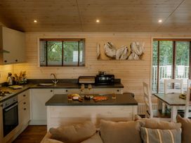 A kitchen with cabinets and a dining table at Spitfire Lodge in Fair Oak