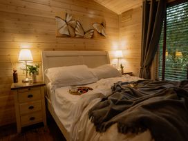 A bedroom with a bed and bedside table at Spitfire Lodge in Fair Oak