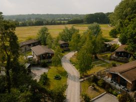 An outdoor area with cabins and a gravel path at Spitfire Lodge in Fair Oak