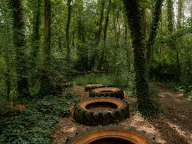 A wooded area with old tires along a path at Spitfire Lodge in Fair Oak