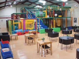 A play area with a soft play structure and seating at Spitfire Lodge in Fair Oak