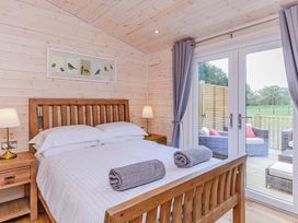 A bedroom with a bed and a double door leading outside at Lancaster Lodge Fair Oak