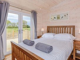 A bedroom with a double bed and sliding doors at Lancaster Lodge in Fair Oak