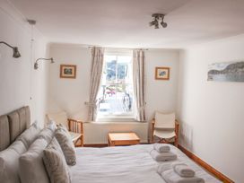 A bedroom with a bed and window view at The Little Clock House in Dartmouth