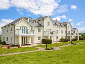A building with balconies and windows surrounded by grass at 8 Thurlestone Beach in Kingsbridge