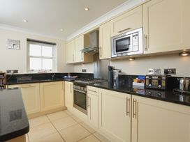 A kitchen with cabinets, stove, and microwave at 8 Thurlestone Beach in Kingsbridge