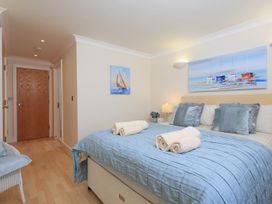 A bedroom with a bed and artwork at 8 Thurlestone Beach in Kingsbridge