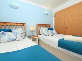 A bedroom with two beds and a bedside table at 8 Thurlestone Beach in Kingsbridge