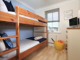 A bedroom with a bunk bed and a television at 8 Thurlestone Beach in Kingsbridge