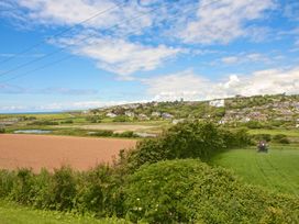 A landscape view of fields, a lake, and houses at 8 Thurlestone Beach in Kingsbridge