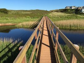 A bridge over water with grass and reeds at 8 Thurlestone Beach in Kingsbridge