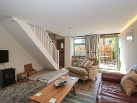A living room with a staircase and a patio door at Wheelwright Cottage in Moreton-In-Marsh