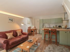 A kitchen and living area with furniture at Wheelwright Cottage in Moreton-In-Marsh