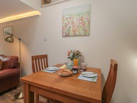 A dining room with a table set for breakfast at Wheelwright Cottage Moreton-In-Marsh