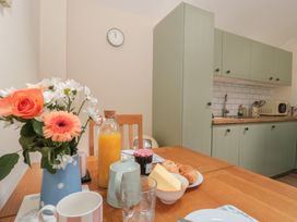 A kitchen with a table set for breakfast at Wheelwright Cottage, Moreton-In-Marsh