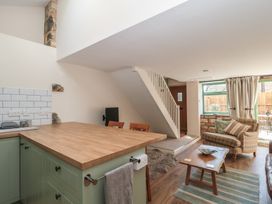 A living room with a kitchen counter and dining area at Wheelwright Cottage in Moreton-In-Marsh