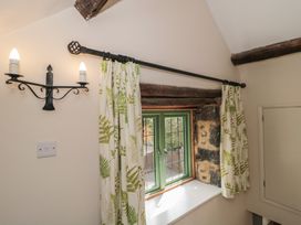 A window with curtains and a light fixture at Wheelwright Cottage in Moreton-In-Marsh