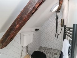 A bathroom with a toilet and shower at Wheelwright Cottage in Moreton-In-Marsh