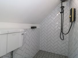 A bathroom with a toilet and shower at Wheelwright Cottage Moreton-In-Marsh