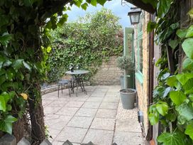 A garden with a table and chairs at Wheelwright Cottage Moreton-In-Marsh