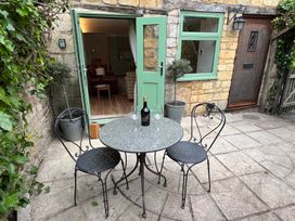 An outdoor patio with a table and chairs at Wheelwright Cottage in Moreton-In-Marsh