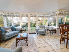 A conservatory with seating and garden view at Llwyn Derw Talybont