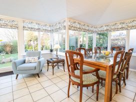 A conservatory with a glass table and chairs at Llwyn Derw Talybont