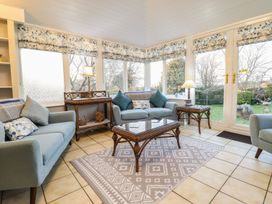 A conservatory with seating and a coffee table at Llwyn Derw in Talybont