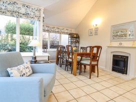 A conservatory with a sofa and dining table at Llwyn Derw in Talybont