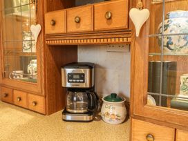 A kitchen with a coffee machine and a coffee canister at Llwyn Derw Talybont