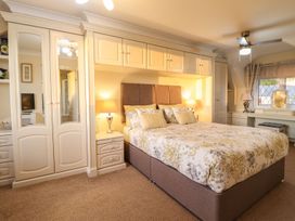 A bedroom with a bed and wardrobe at Llwyn Derw Talybont