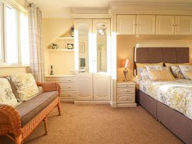A bedroom with a bed and sofa at Llwyn Derw in Talybont